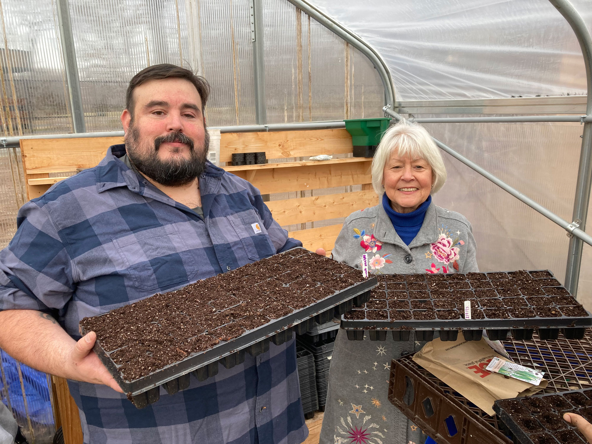 Jorge holding seed trays with Christie Vilsack, Master Gardener and wife of USDA Secretary Tom Vilsack