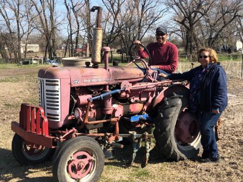 A man on a tractor with a woman beside him